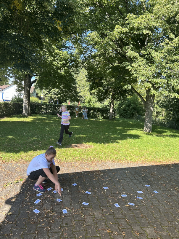 Einige spielende Kinder auf dem Rasen vom TV Vereinsheim-Gelände.